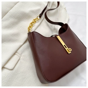 Gros plan d'un sac demi-lune vintage en cuir avec boucle dorée et bandoulière chaîne