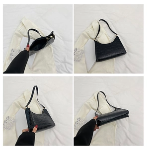Detailfoto's van zwarte hobo-tas met krokodillenpatroon, gouden rits en schouderband