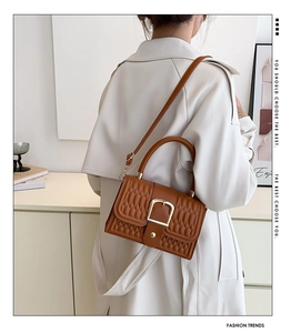 Borsa in pelle PU trapuntata marrone con fibbia dorata indossata da una modella elegante