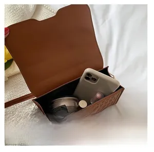 Vista interna della borsa a tracolla quadrata marrone goffrata con trucco e cellulare