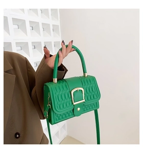 Dettaglio borsa trapuntata verde con fibbia quadrata dorata e finitura in ecopelle