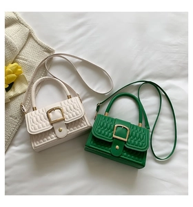 Dettaglio di borse in pelle PU goffrata color crema e verde con fibbie dorate