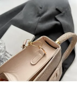 Close-up of premium gold hardware and shimmering sequins on a light beige PU handbag