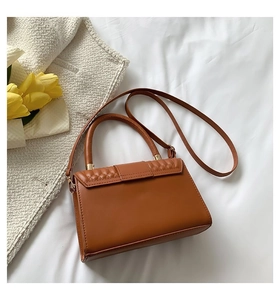 Dettaglio della borsa in pelle caramello con motivi a rilievo e accessori dorati