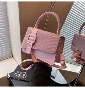 Close-up of pink sequin crossbody bag with gold buckle and adjustable strap detail