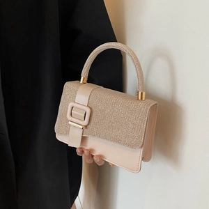 Detail of the glittering rhinestone-encrusted handle and large buckle on the nude PU handbag