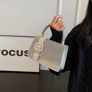 Detailed view of elegant white PU bag with silver sequins and a large square buckle