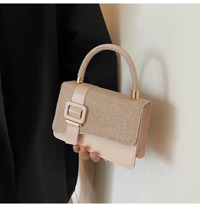 Close-up of pink PU leather handbag featuring shimmering glitter flap and gold buckle