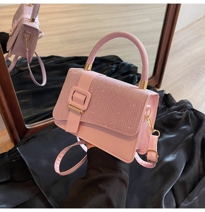Detail of pink PU leather handbag with sparkling glitter rhinestones and gold hardware