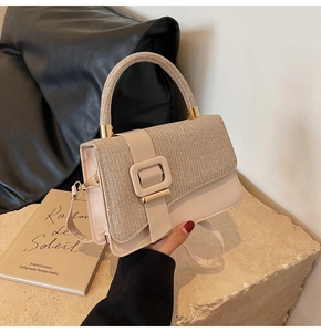 Detail of cream PU leather handbag with shimmering diamond-encrusted flap and top handle