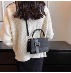 Detail of the structured black PU crossbody bag with matte and glittery fabric textures