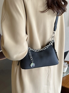 Minimalist black faux leather underarm bag with thick silver chain and metal charm