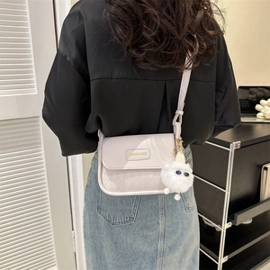 Borsa a tracolla trapuntata in pelle beige con accessorio pompon e tracolla