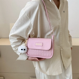 Borsa a tracolla rosa trapuntata con ciondolo di peluche indossata da una modella
