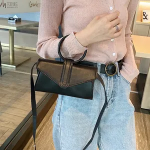Borsa a busta nera minimalista con manico circolare in metallo e tracolla regolabile