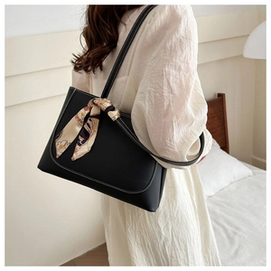 Large black leather tote bag with white contrast stitching and a decorative silk scarf