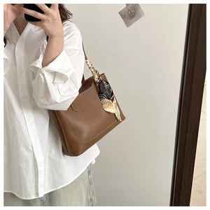 Brown leather tote bag featuring an elegant floral silk scarf detail and shoulder strap