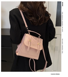 Detail der glatten rosa Ledertextur mit goldenen Metallschnallen am Flap-Rucksack