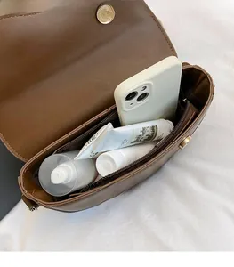 Internal view of brown saddle bag showing spacious compartments and magnetic closure