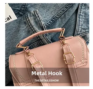 Macro detail of golden metal hooks and pink leather straps on a travel backpack