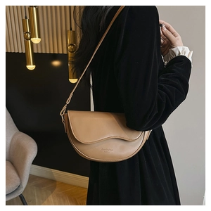 Detail of khaki crescent shoulder bag with wavy flap and embossed fashion lettering