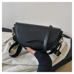 Detail of black saddle bag with matte leather texture and dual shoulder strap options