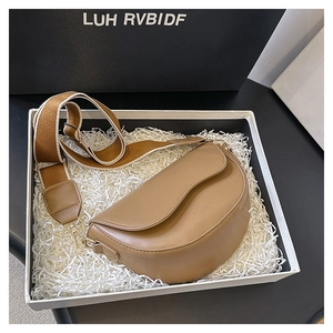 Detail view of khaki saddle bag in a gift box with a wide fabric shoulder strap