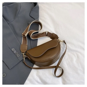 Detailed view of brown saddle bag with two interchangeable wide and slim shoulder straps