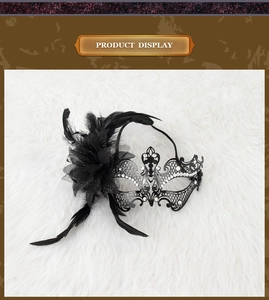 Detail of masquerade mask featuring black feathers, silk flower and sparkling rhinestones
