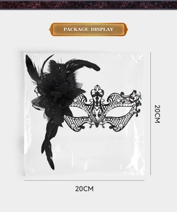 Detailed view of black feather lace masquerade mask with rhinestones in package