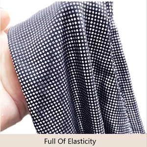 Close-up of black polka dot fabric showing high elasticity for catwoman cosplay costume