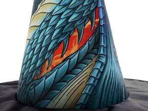 Macro view of blue dragon scales and orange flame patterns on a fabric witch hat