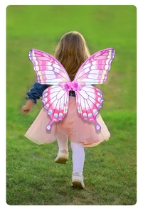 Outdoor shot of a young girl wearing pink and purple gradient butterfly wings for Easter