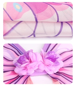 Detailed view of pink butterfly wings mesh fabric and decorative faux flowers