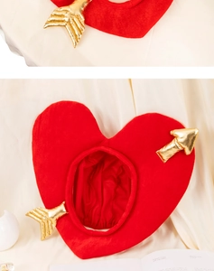Détail de coiffe en forme de cœur rouge en peluche avec flèches de Cupidon dorées pour fêtes