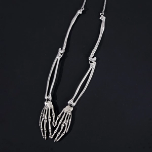 Macro detail of silver skeleton hand necklace with articulated bone joint structure
