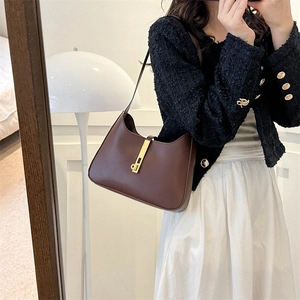 Sac hobo vintage en cuir marron avec un fermoir métallique doré à bouton-poussoir