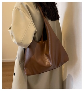 Brown large-capacity tote bag shown from side back view on model during daily commute
