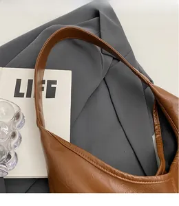 Detail of premium brown textured leather shoulder strap and stitching on a tote bag
