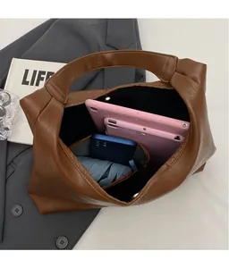 Interior view of brown faux leather hobo bag showing space for tablet and phone