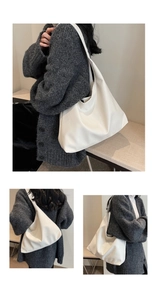 Detail view of large white minimalist Hobo bag showing soft pebble leather texture and fit