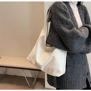 Close-up of white oversized PU leather tote bag with subtle grain texture for daily commuting