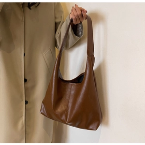 Macro detail of high-quality dark brown faux leather tote with reinforced stitching