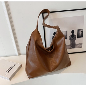 Detailed view of brown glossy leather tote bag with elegant texture and magnetic closure