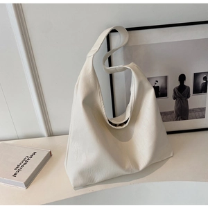 Detail of minimalist beige hobo tote bag featuring smooth PU texture and magnetic closure