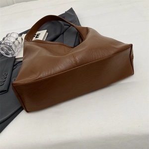 Detail of deep brown faux leather tote bag with reinforced seams and spacious base