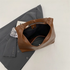 Detailed view of caramel brown tote bag interior with magnetic closure and zip pocket