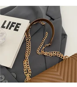 Detail of brown V-quilted leather crossbody bag with golden chain and leather strap