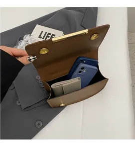 Internal view of the brown leather crossbody bag showing large capacity for phones and wallet