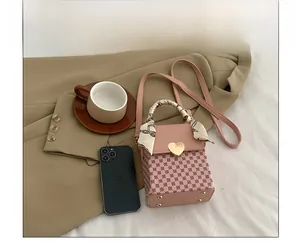 Chic pink plaid small square bag with heart lock and silk scarf handle on stylish desk